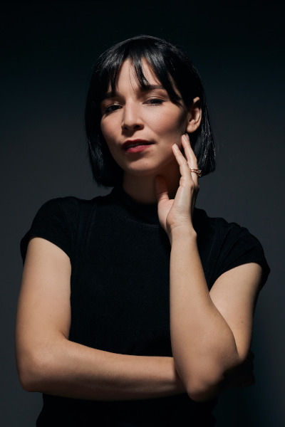 photo portrait of Zayra Estrada with a grey background and wearing a black shirt