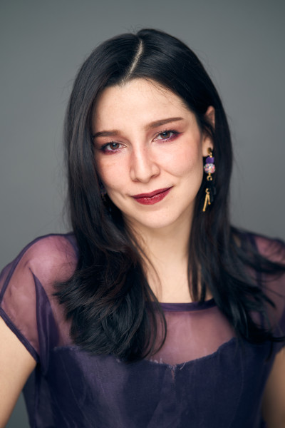 photo portrait of Zayra Estrada with a grey background and wearing a black shirt